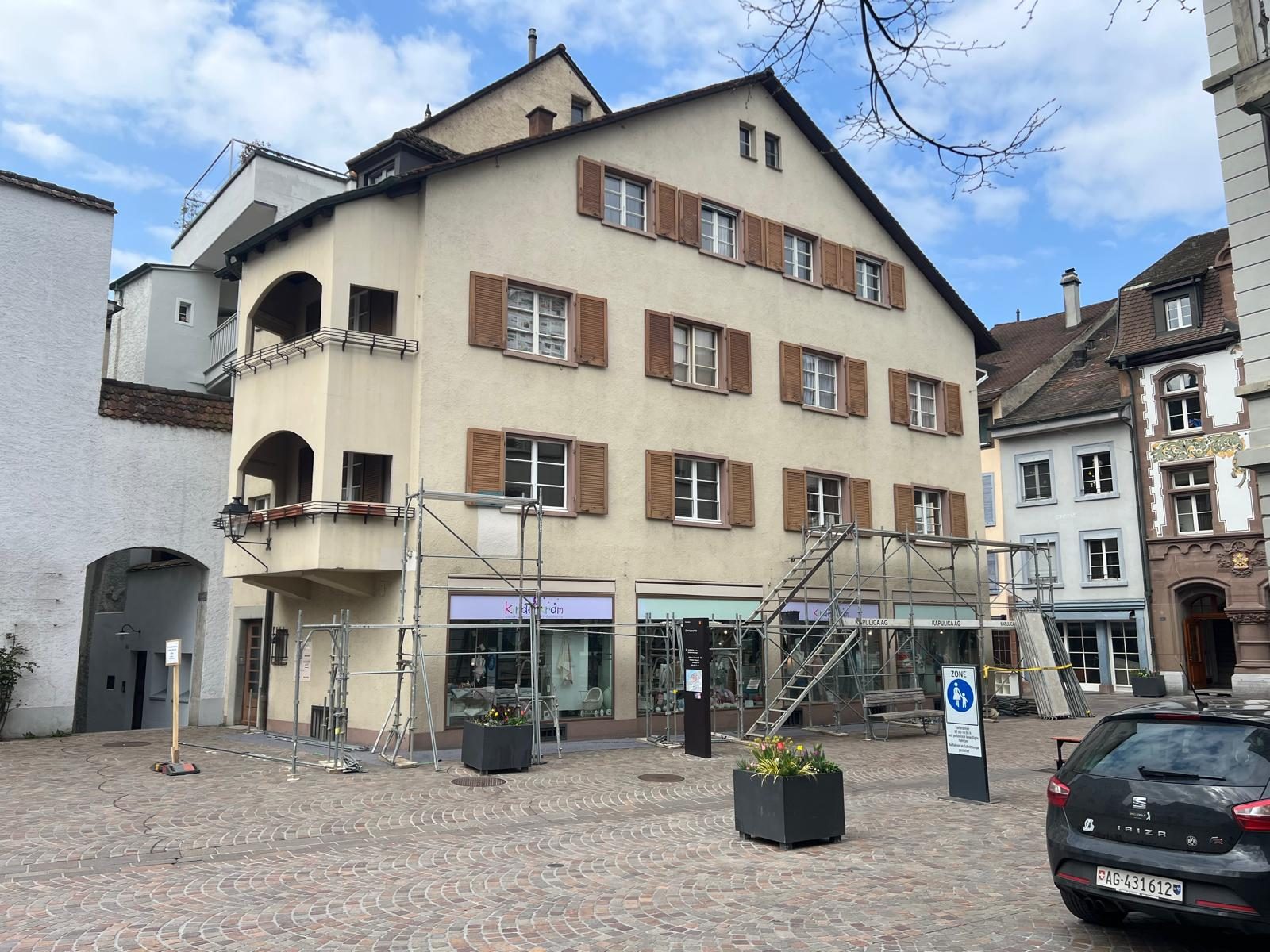 Fassade an der Marktgasse vor der Sanierung, mit Gerüst und verwittertem Anstrich